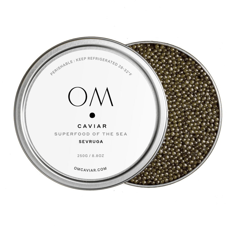 Open tin of Limited Edition Sevruga Caviar with grey-brown medium-sized pearls and minimalist white label on lid.